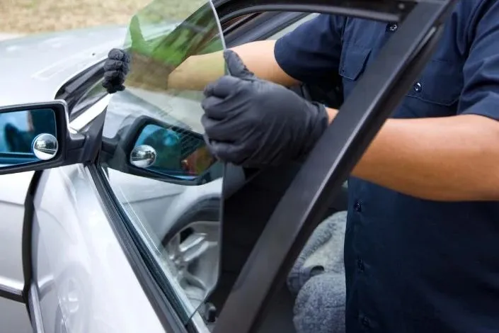 Technician replacing a broken car door window in Las Vegas